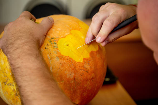 istock man carving on a pumpkin 1068662994