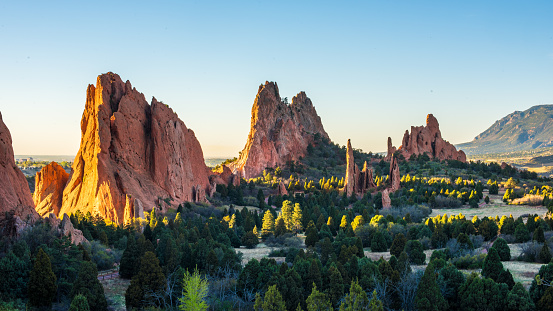 Sunlight peaks through the Garden of the Gods in Colorado Springs at sunrise.