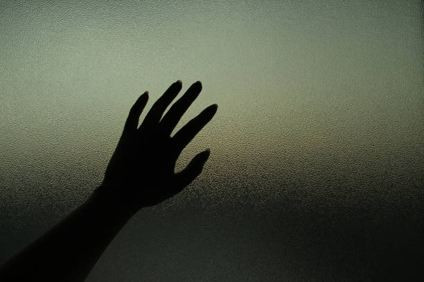 silhouette of hands on frosted glass - strangling imagens e fotografias de stock