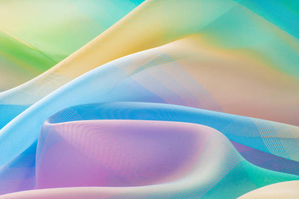 istock Texture, background, pattern. Silk fabric is transparent, yellow-pink green in blue. Abstract soft chiffon texture background. 1068678614