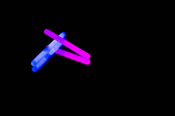 Colorful fluorescent light neon big glow stick on mirror reflection black background