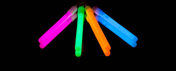 Colorful fluorescent light neon big glow stick on mirror reflection black background