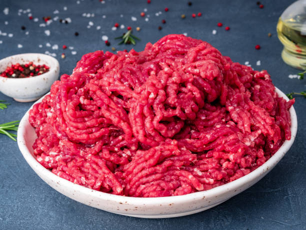 istock Mince beef, ground meat with ingredients for cooking on dark blue background, side view, close up 1068685436