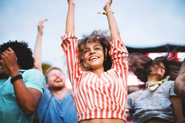 Photo of People dancing at concert.