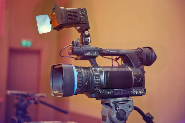 professional digital video camera. accessories for 4k video cameras. tv camera in a concert hall. video camera lens - recording show in tv studio - focus on camera aperture - camera lens home video camera broadcasting imagens e fotografias de stock