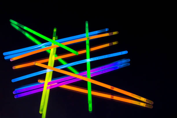 Colorful fluorescent light neon big glow stick on mirror reflection black background