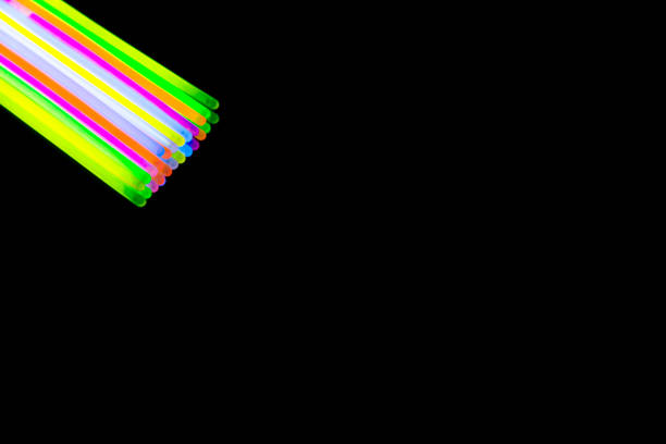 Colorful fluorescent light neon big glow stick on mirror reflection black background
