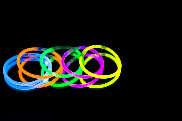 istock Colorful fluorescent light neon glow stick bracelet strap wristband on mirror reflection black background 1068698858