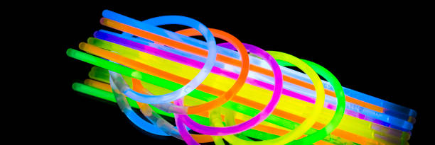 istock Colorful fluorescent light neon glow stick bracelet strap wristband and tubes on mirror reflection black background 1068700904