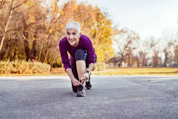 last prep before the run - shoe tying adult jogging imagens e fotografias de stock