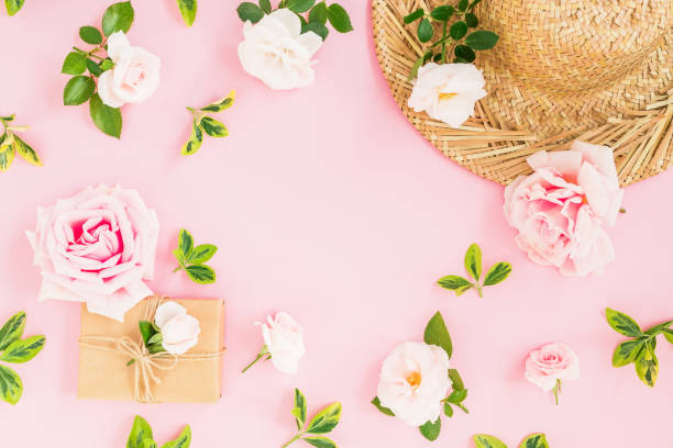 istock Valentines day composition. Floral frame with gentle roses, straw hat and gift box on pastel pink background. Flat lay, top view. 1068706410