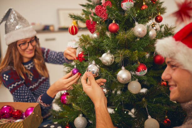 istock Happy couple decorating tree for New Year's / Christmas eve. 1068706730
