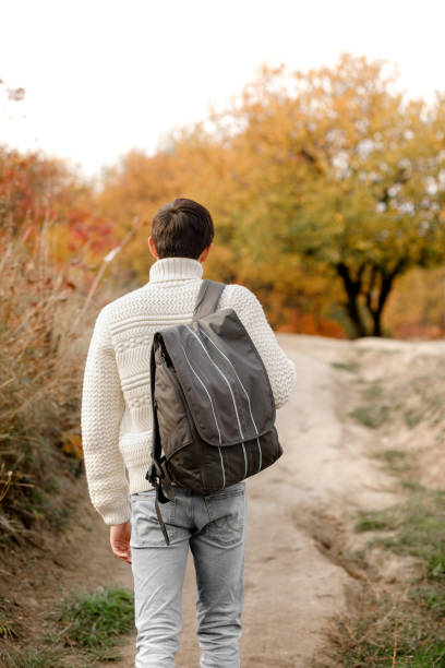 istock young man tourist with backpack walking up the trail path 1068721372