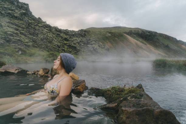 Woman resting in hot natural pool in Iceland Young Caucasian woman resting in hot natural pool in Iceland woman cold water swimming stock pictures, royalty-free photos & images