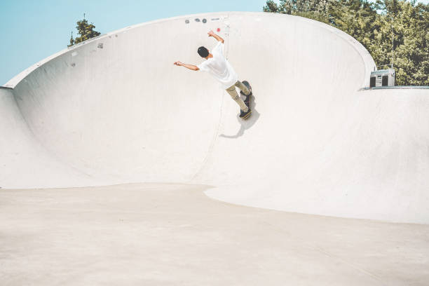 skater występujący na rampie skate parku - młody człowiek jeżdżący na deskorolce w miejskim miejscu - sport ekstremalny, młodzież i modny styl życia pokolenia z - skup się na nim - skateboard park zdjęcia i obrazy z banku zdjęć