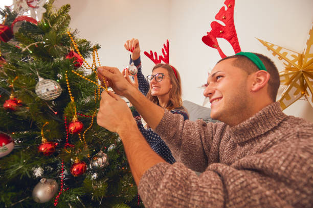 istock Happy couple decorating tree for New Year's / Christmas eve. 1068723768