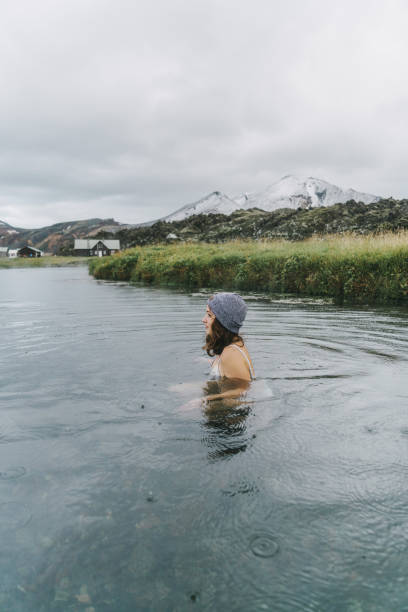 Woman resting in hot natural pool in Iceland Young Caucasian woman resting in hot natural pool in Iceland woman cold water swimming stock pictures, royalty-free photos & images