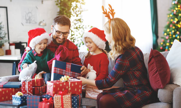 happy family   open presents on Christmas morning happy family parents and children open presents on Christmas morning unwrapping stock pictures, royalty-free photos & images