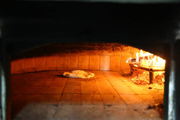 istock Bread in front of ancient burning wood oven 1068743236
