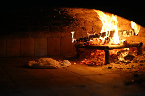 istock Bread in front of ancient burning wood oven 1068743290