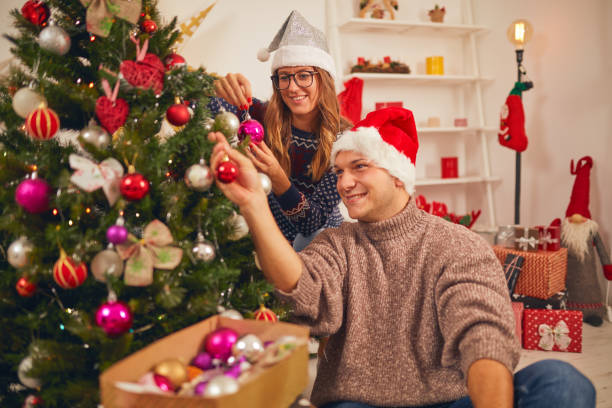 istock Happy couple decorating tree for New Year's / Christmas eve. 1068746150