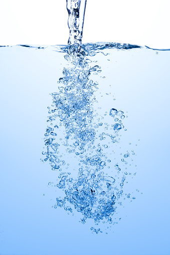 Pouring water splash with air bubbles in blue white water background