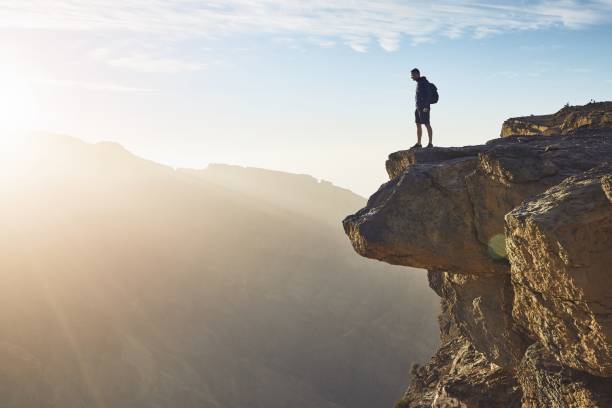 tourist on the edge of cliff - wadi warning imagens e fotografias de stock