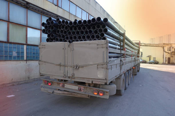 istock Old truck loaded with black plastic pipes. Back view. 1068755556