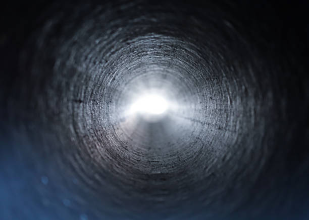 istock Inside view of a round plastic pipe. Tunnel to the light from the dark 1068755686