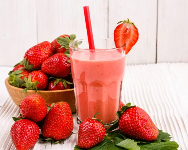 fresh strawberrysmoothie or milkshake on a wooden rustic background.