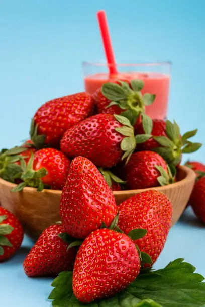 fresh strawberrysmoothie or milkshake on a delicately blue background.