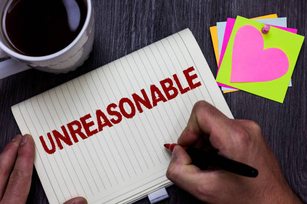 istock Conceptual hand writing showing Unreasonable. Business photo text Beyond the limits of acceptability or fairness Inappropriate Man holding marker giving ideas wooden table cup coffee hearts. 1068763524