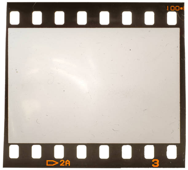 Real macro photo of old and grungy 35mm film frame or strip on white with signs of usage, dust and film grain stock photo
