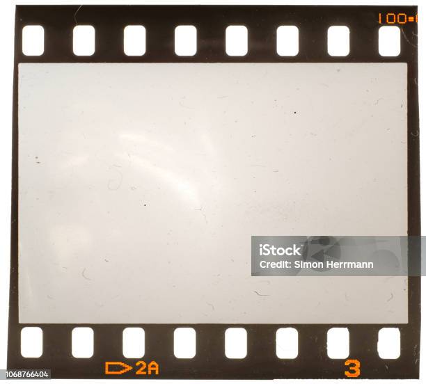 Real Macro Photo Of Old And Grungy 35mm Film Frame Or Strip On White With Signs Of Usage Dust And Film Grain Stock Photo - Download Image Now