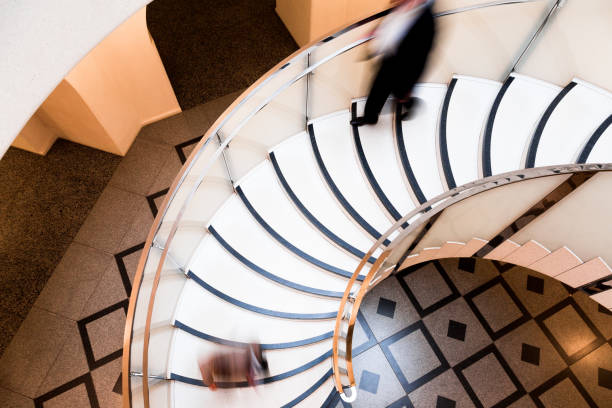 istock Motion Blur of People on Abstract Spiral Staircase 1068767088