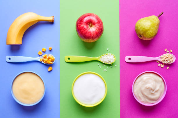 Baby porridges on blue, green and pink, from above Three bowls of porridge for babies isolated on blue, green and pink background, top view baby food stock pictures, royalty-free photos & images