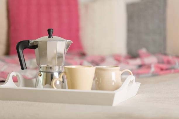 istock Breakfast in bed. On a white wicker tray there is a coffee maker, coffee cups and croissants. 1068776168