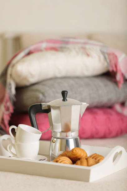 istock Breakfast in bed. On a white wicker tray there is a coffee maker, coffee cups and croissants. 1068776174