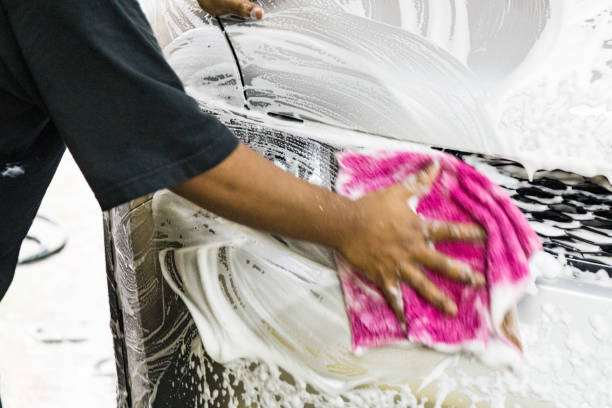 istock Worker wipe clean car using detergent soap foam with cloth 1068777752