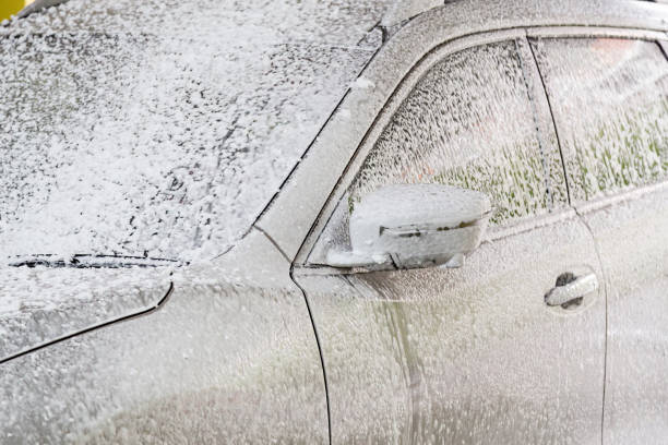 istock Detergent soap foam known as snow wash sprayed onto car 1068777860