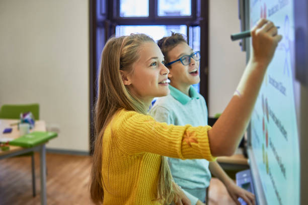 compagni di scuola che lavorano insieme su un progetto - lavagna bianca foto e immagini stock