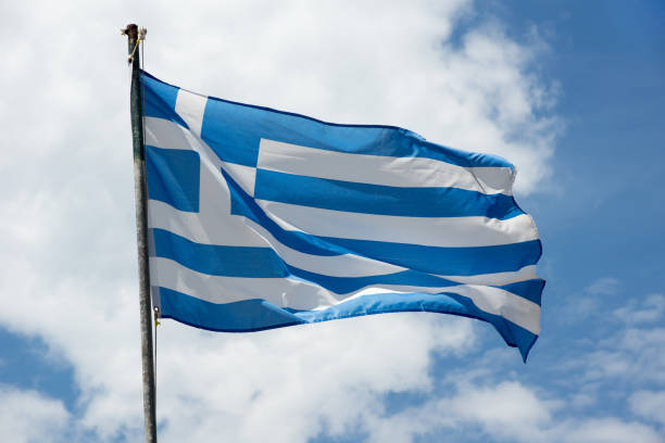 istock Waving Greece flag on skyscape background 1068785370