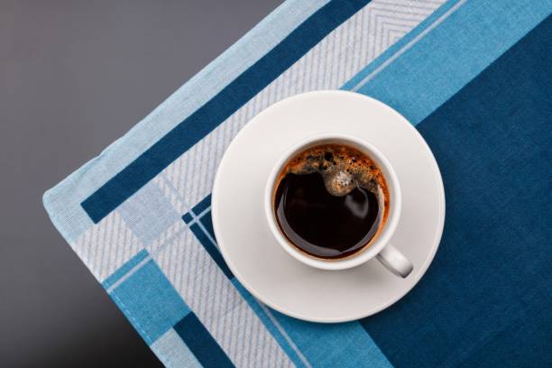 istock Top view of a black coffee cup on fabric background. 1068789224