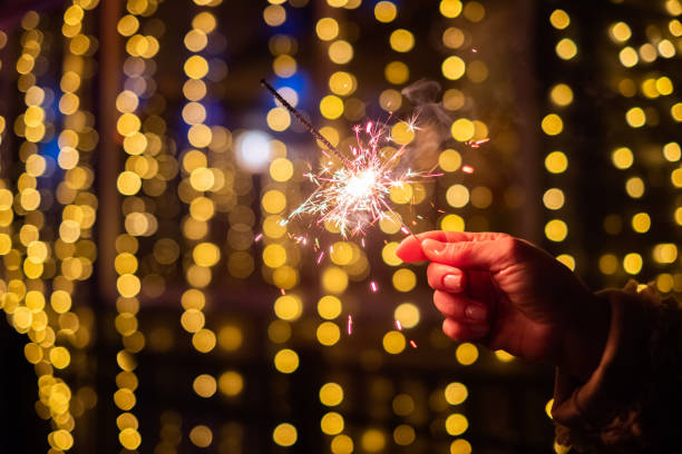 istock Person celebrating at night by holding sparkler 1068791042