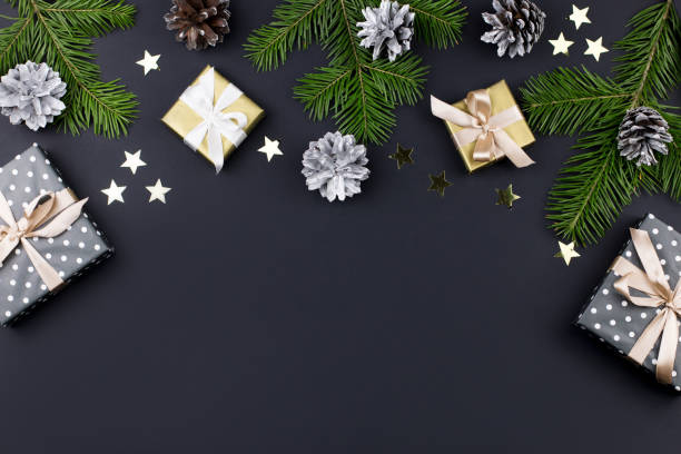 istock Festive Christmas background with fir branches, presents, decorations on black, copy space 1068797326