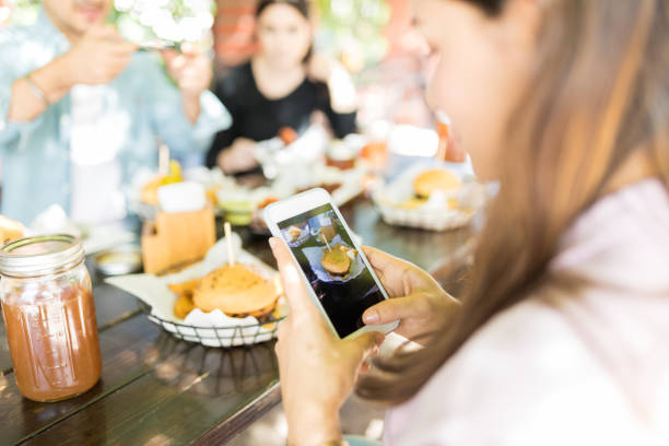 istock Woman Sharing Cheeseburger Pictures On Networking Site 1068798764