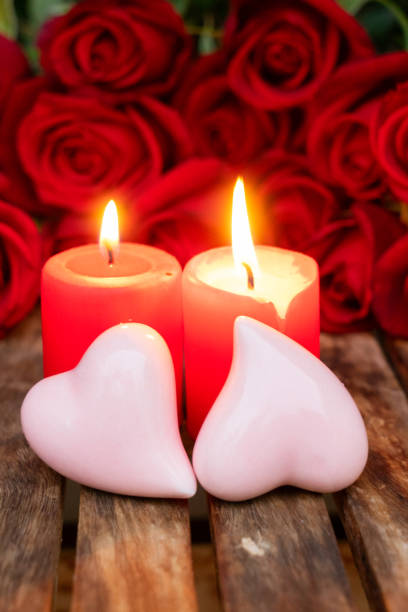 istock Two burning candles with fresh roses 1068800266