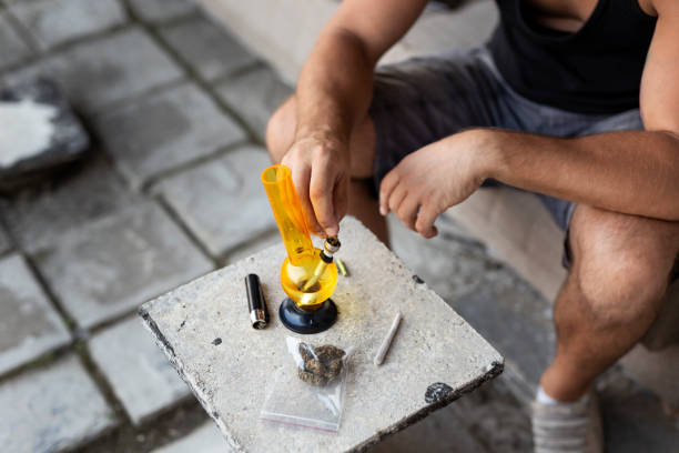 istock Man filling up the bong with ganja 1068805140