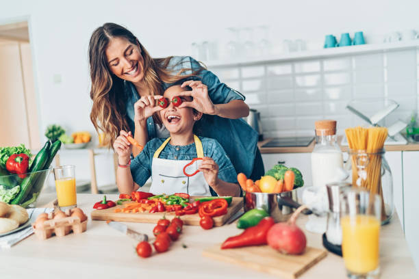 istock Mother and daughter playing with cherry tomatoes 1068812910