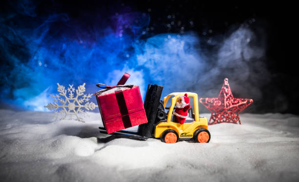istock Miniature Gift Box by Forklift Machine on snow ,Determined Image for Christmas Holiday and Happy New Year Gift Celebration concept. 1068825752
